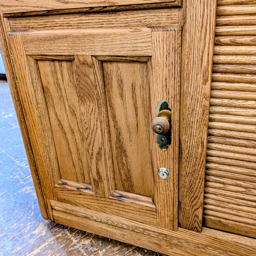 Wooden cabinet with a door and handle on a blue floor.