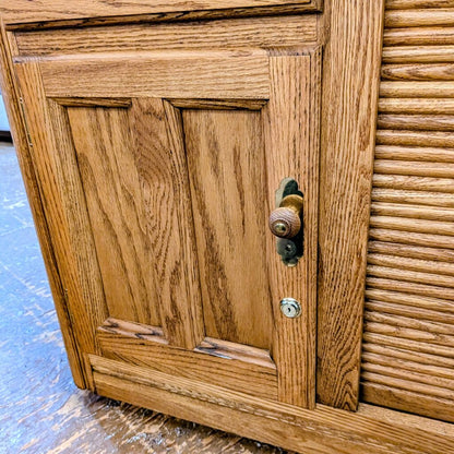Wooden cabinet with a door and handle on a blue floor.