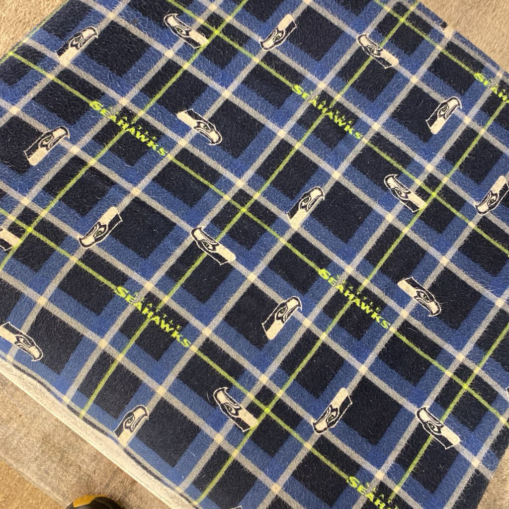 Plaid blanket with Seahawks logo and text on a checkered pattern