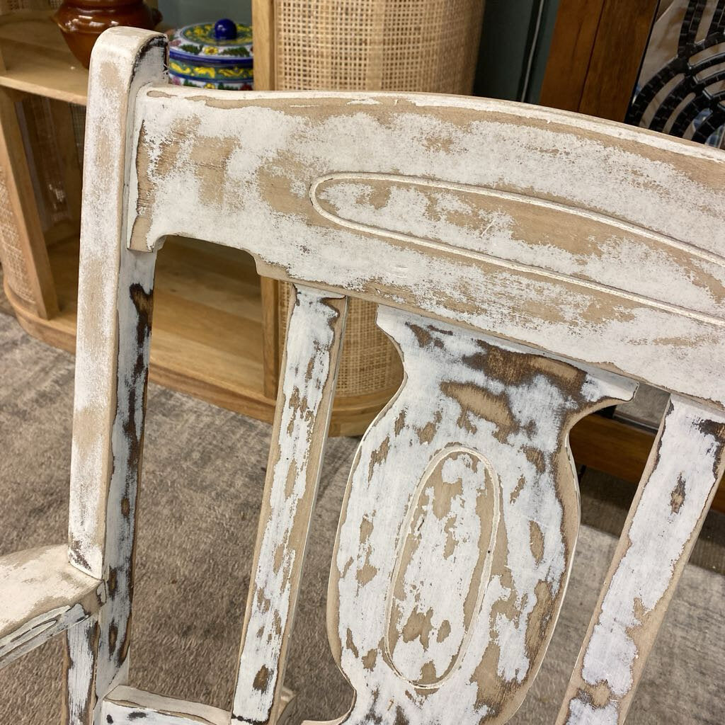 Distressed wooden chair with peeling paint in a room setting