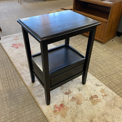 Black side table on a patterned rug