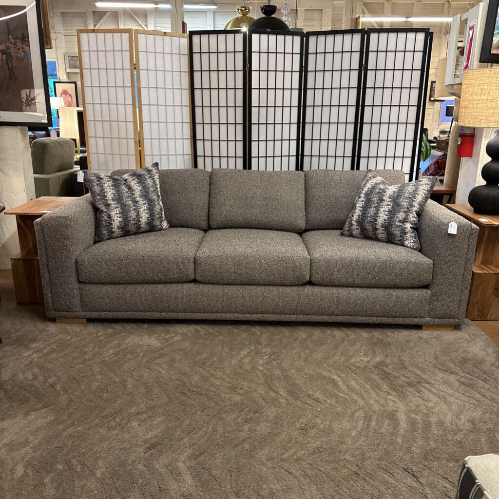 Gray sofa with decorative pillows in a store setting