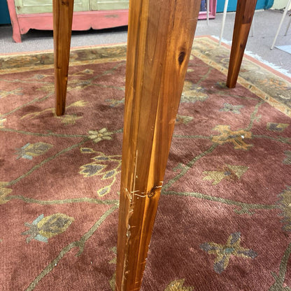 Close-up of a wooden chair leg on a patterned carpet
