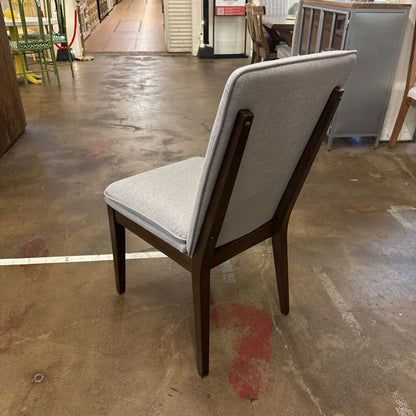 Chair with gray cushion on a concrete floor in an indoor setting