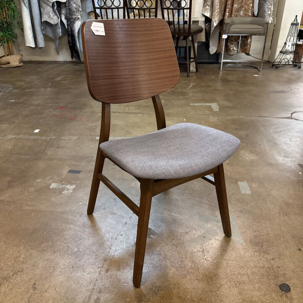 Wooden chair with a gray cushion on a concrete floor