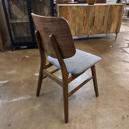 Wooden chair with a gray cushion on a concrete floor.