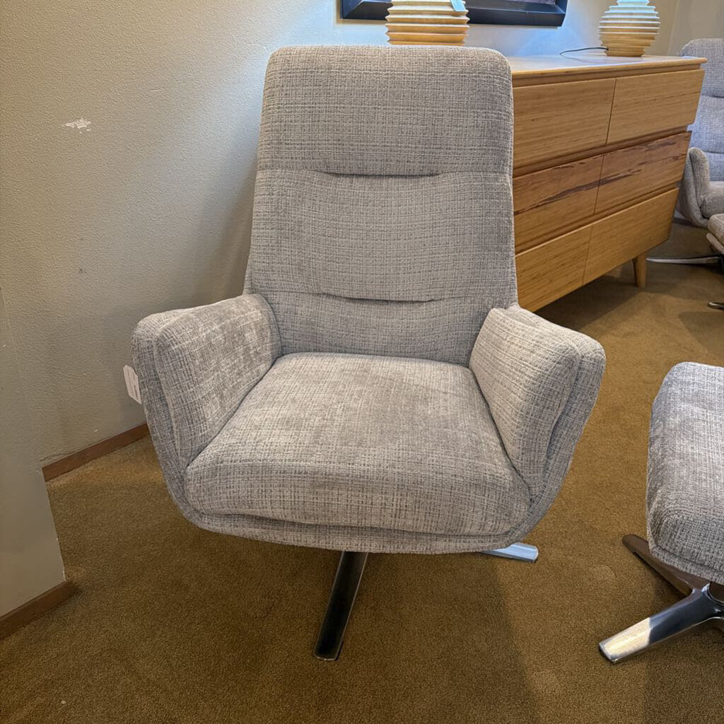 Gray armchair in a room with a wooden dresser.