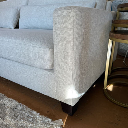 Gray textured sofa with a wooden chair on a wooden floor