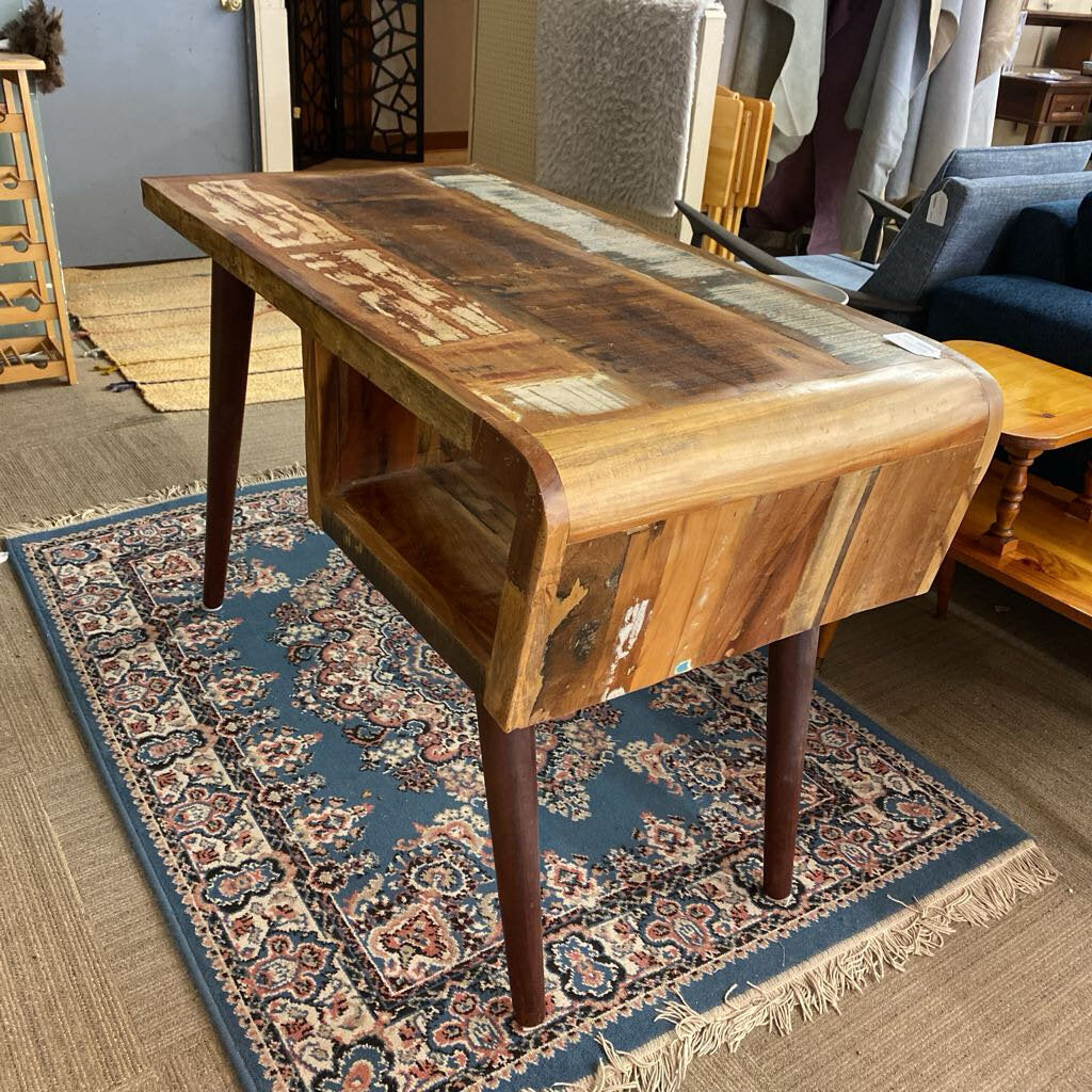 Wooden table on a patterned rug in a room with furniture