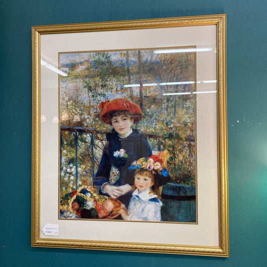 Framed artwork of two women on a balcony with a gold frame.