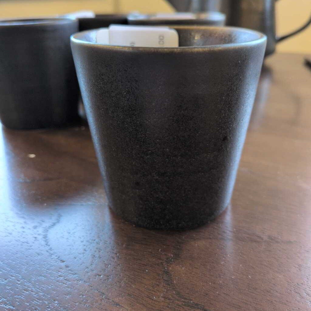 Black ceramic cup on a wooden surface