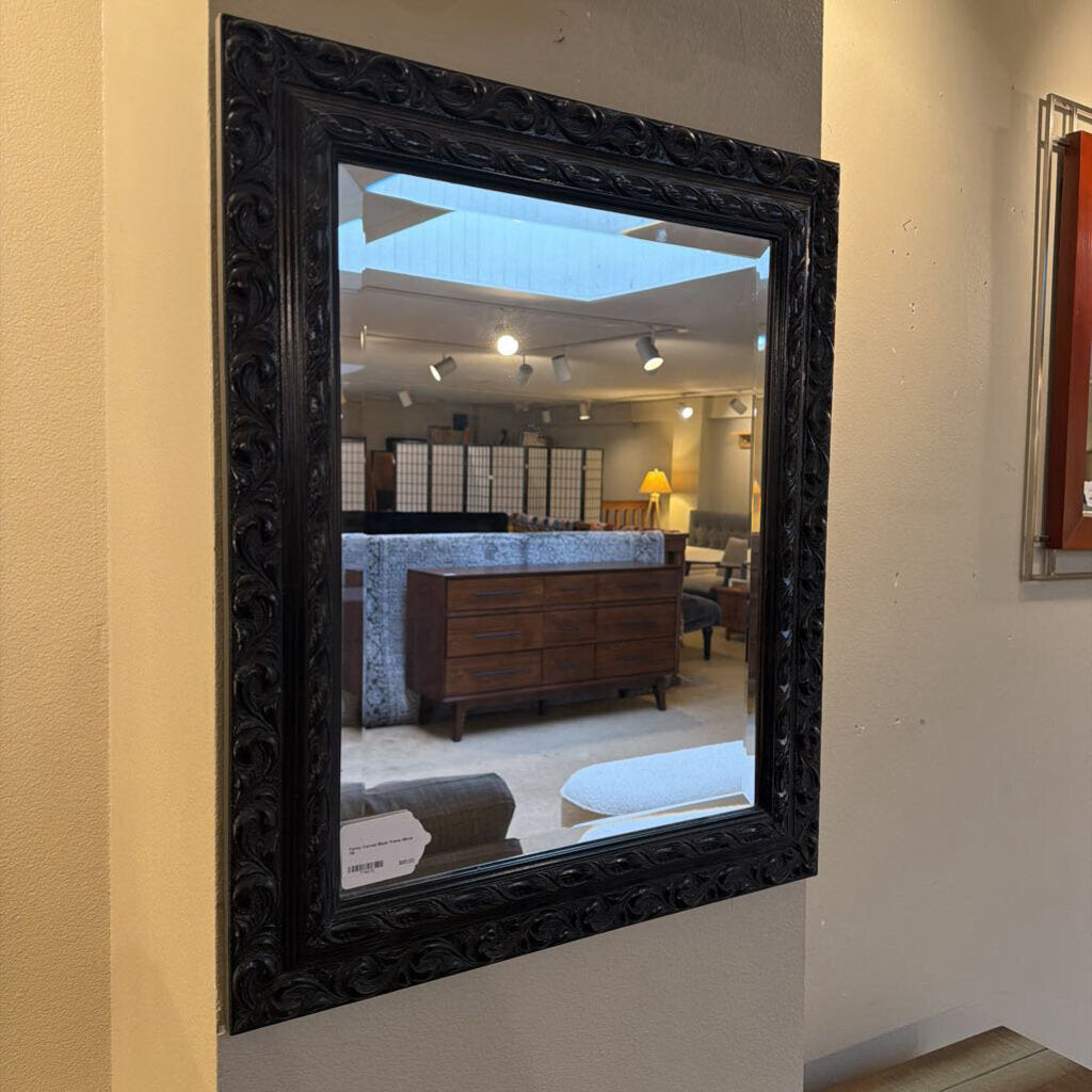 Decorative black-framed mirror on a wall