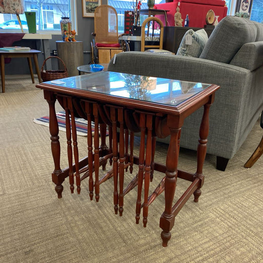 Wooden table with glass top in a room with furniture and decor