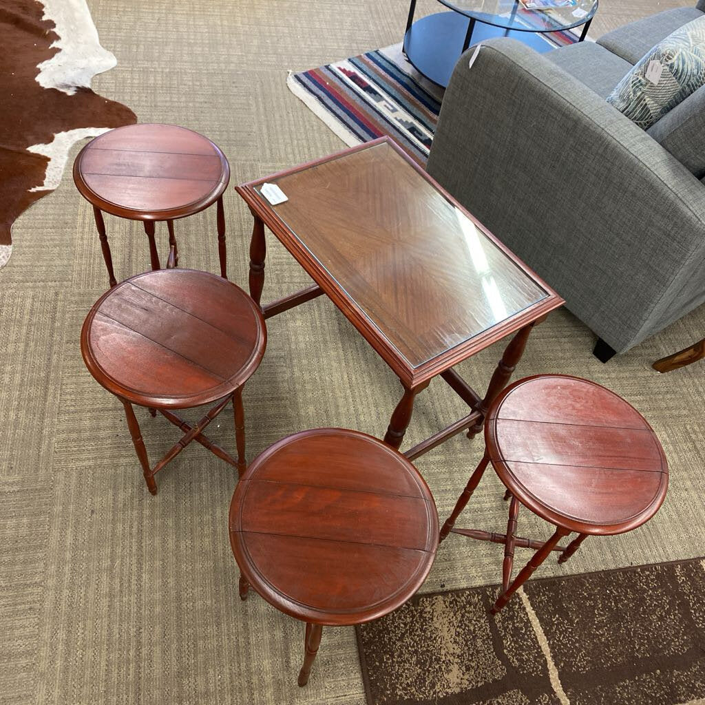 Wooden table with four stools on a carpeted floor