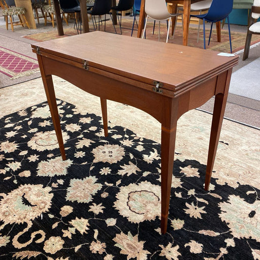 Wooden table with a hinged top on a decorative rug