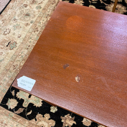 Brown leather sample with a label on a patterned rug