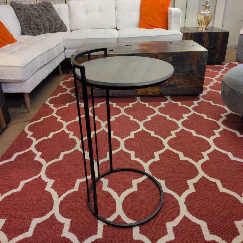 Living room with a red patterned rug, white sofa, and wooden coffee table.