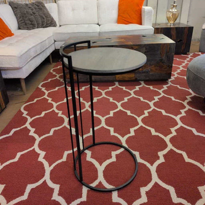 Living room with a red patterned rug, white sofa, and wooden coffee table.