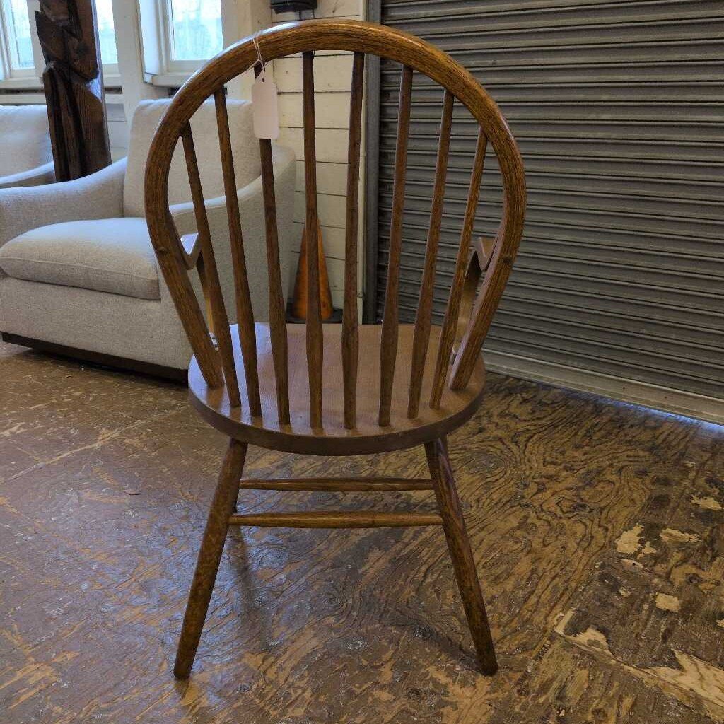 Wooden chair with a tag on a patterned floor