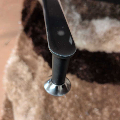 Close-up of a black metal handle on a textured surface