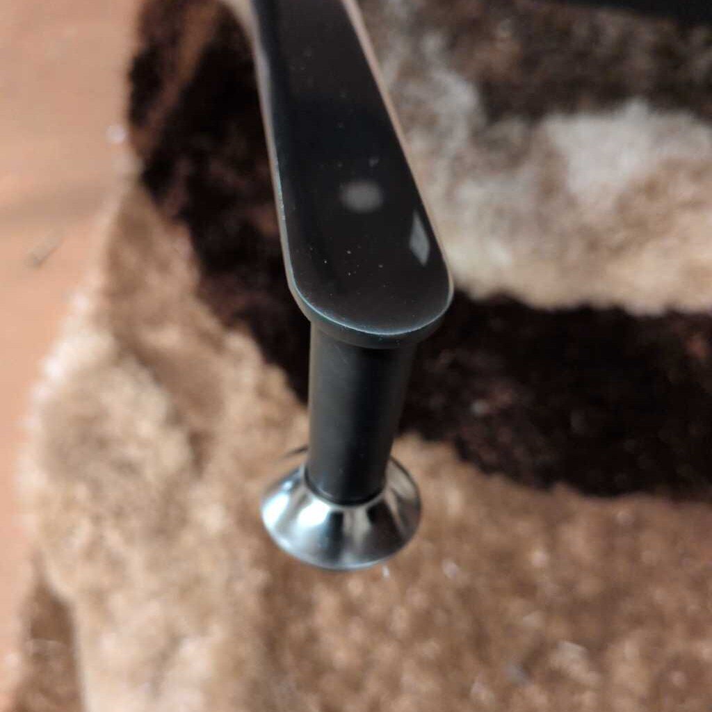 Close-up of a black metal handle on a textured surface