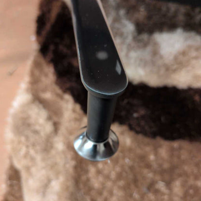Close-up of a black metal handle on a textured surface