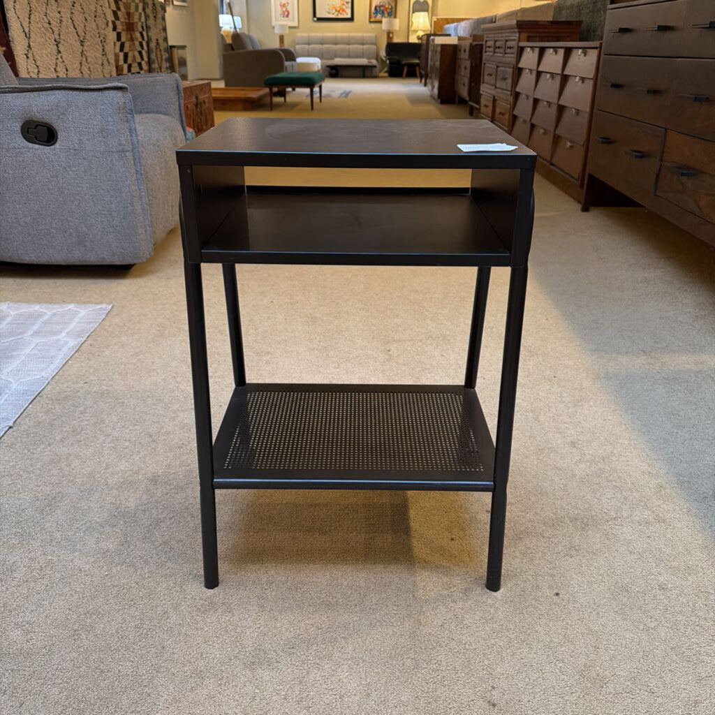 Black metal side table in a furniture store setting