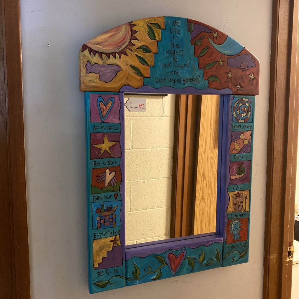 Decorative mirror with colorful frame on a wall