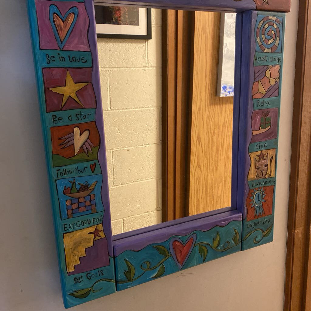 Colorful mirror with decorative frame on a wall