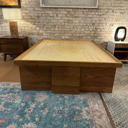 Wooden coffee table in a room with a brick wall and lamps.