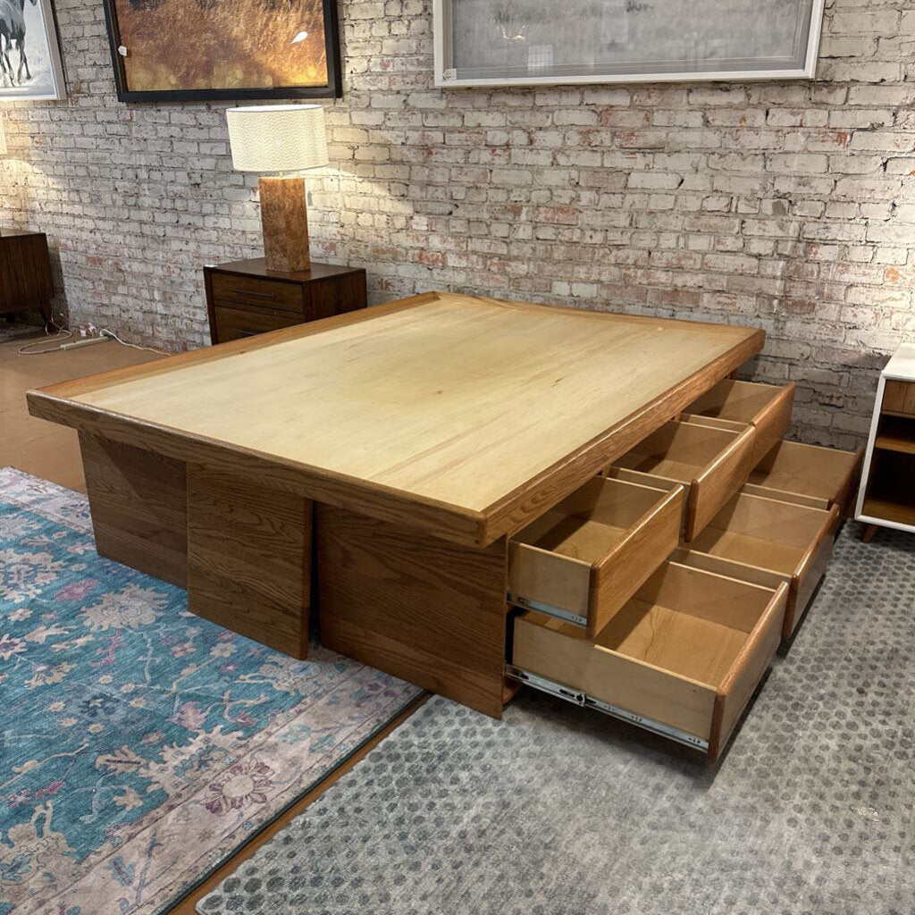 Wooden table with storage drawers in a room with brick walls and a lamp.