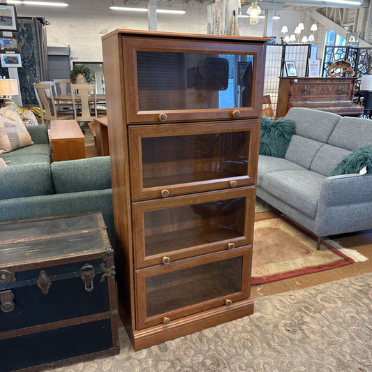 Wooden bookshelf with glass panels in a furniture store setting