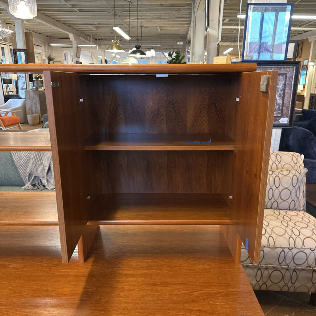 Wooden bookshelf in a store setting with furniture and decor in the background