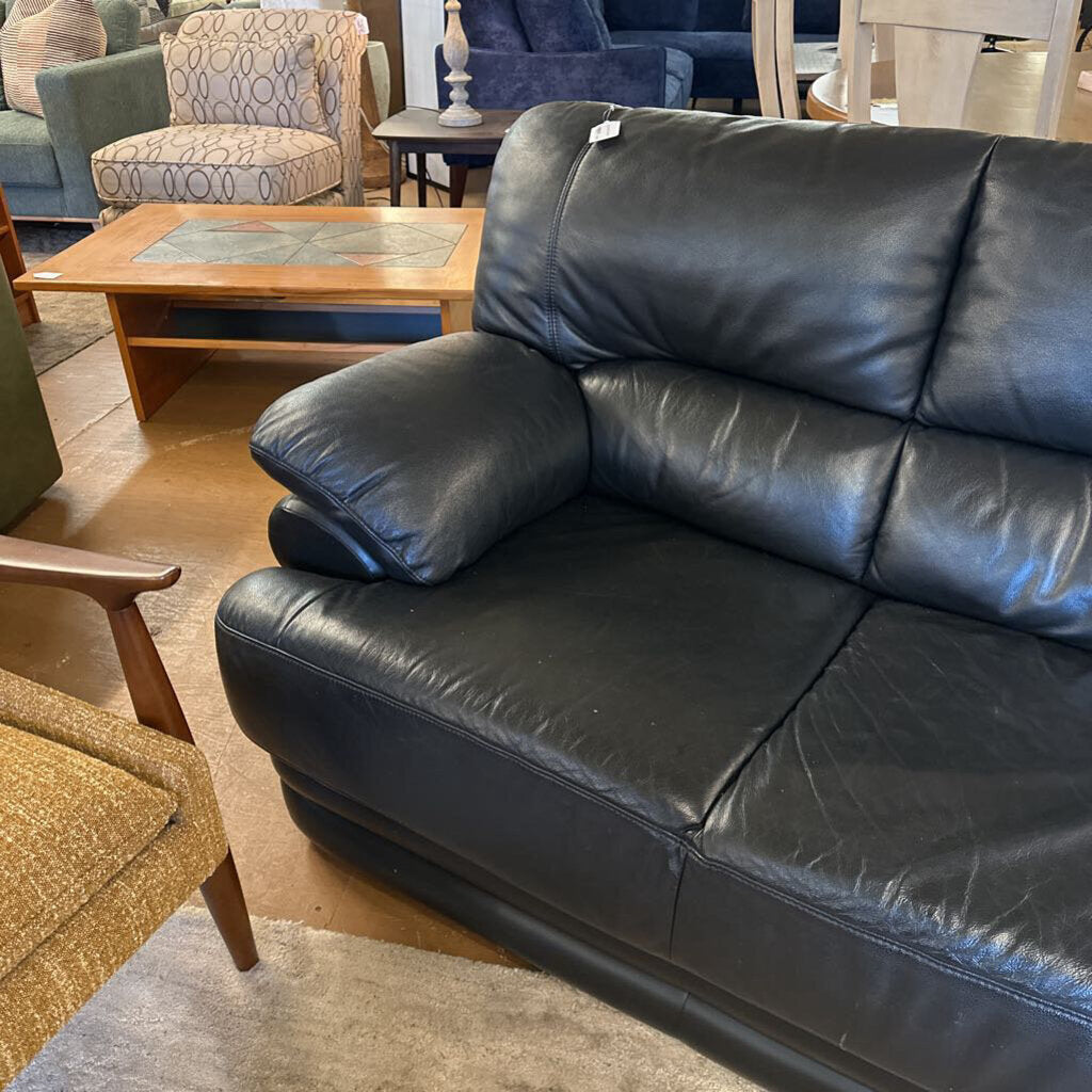 Black leather sofa in a room with other furniture