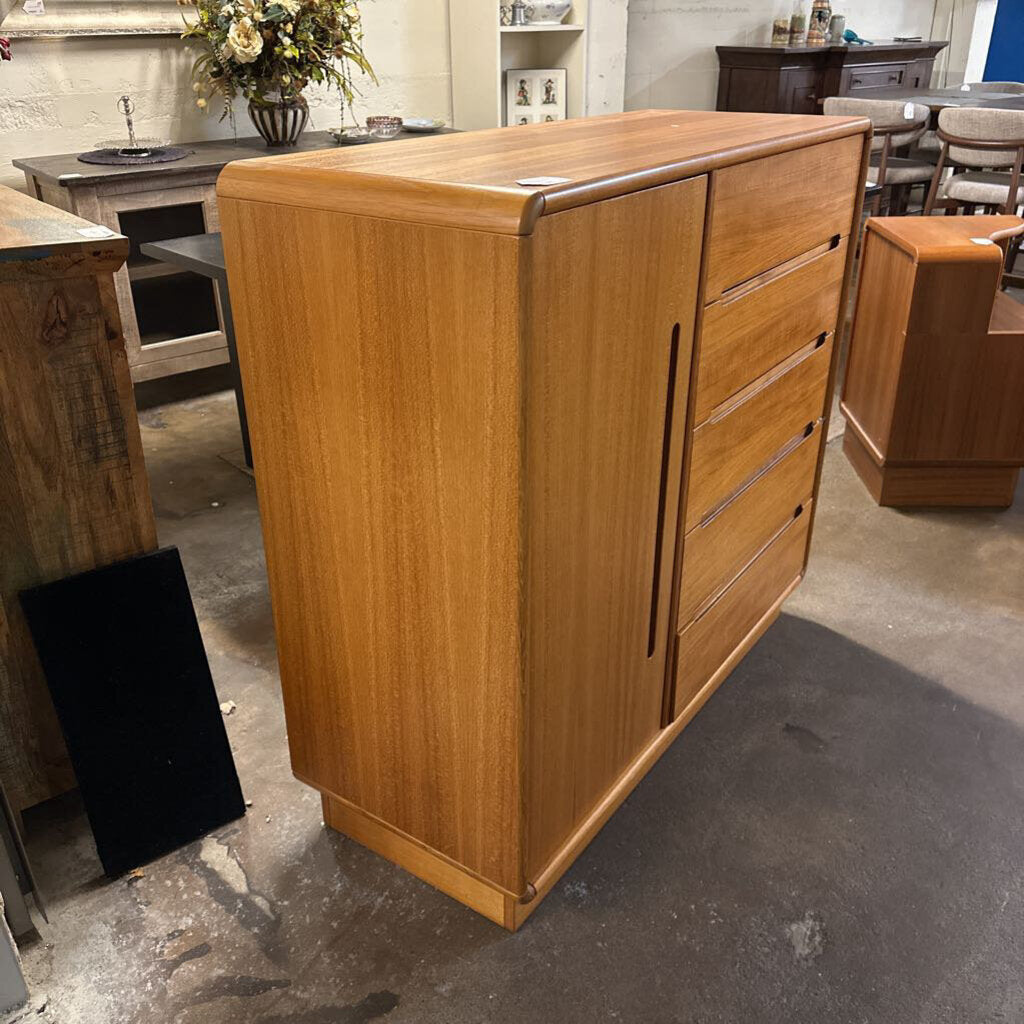 Wooden cabinet in a showroom setting with other furniture pieces.