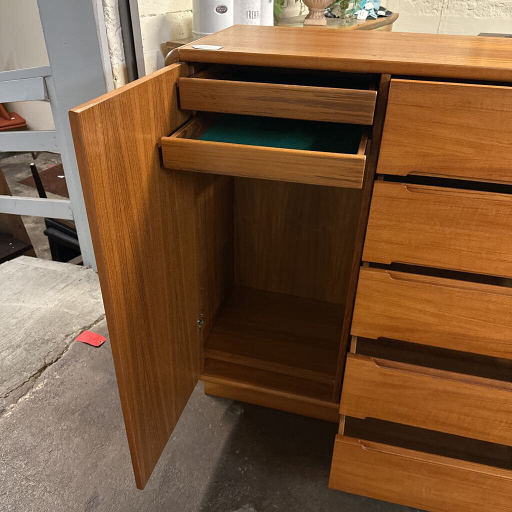 Wooden cabinet with an open door and drawers on a concrete floor.