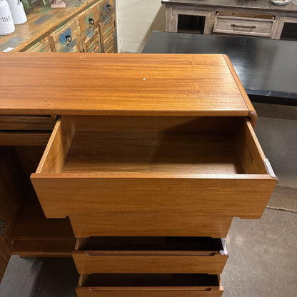 Wooden dresser with open drawer in a room setting