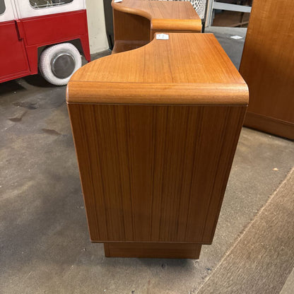 Wooden side table on a concrete surface with a red vehicle in the background