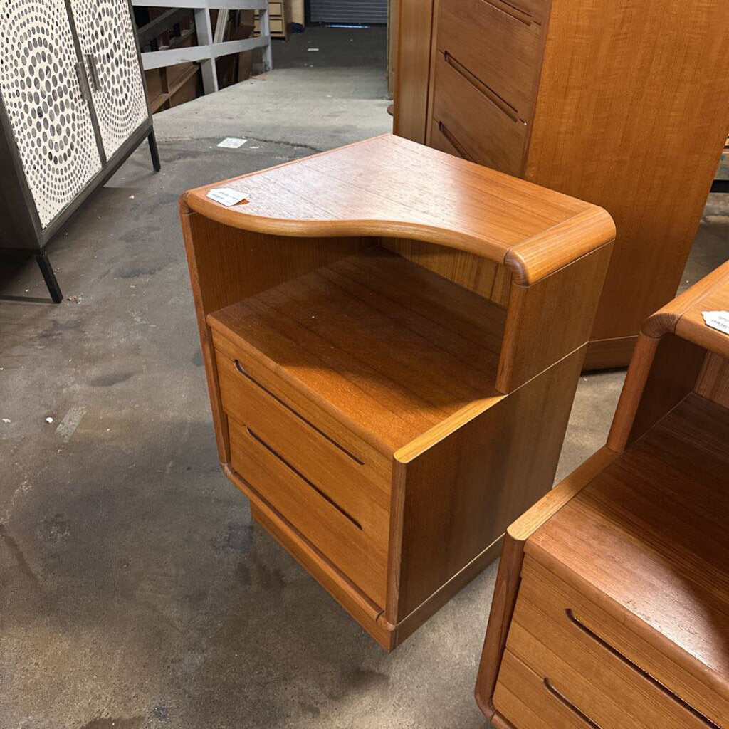 Wooden nightstands with curved tops in a storage or warehouse setting