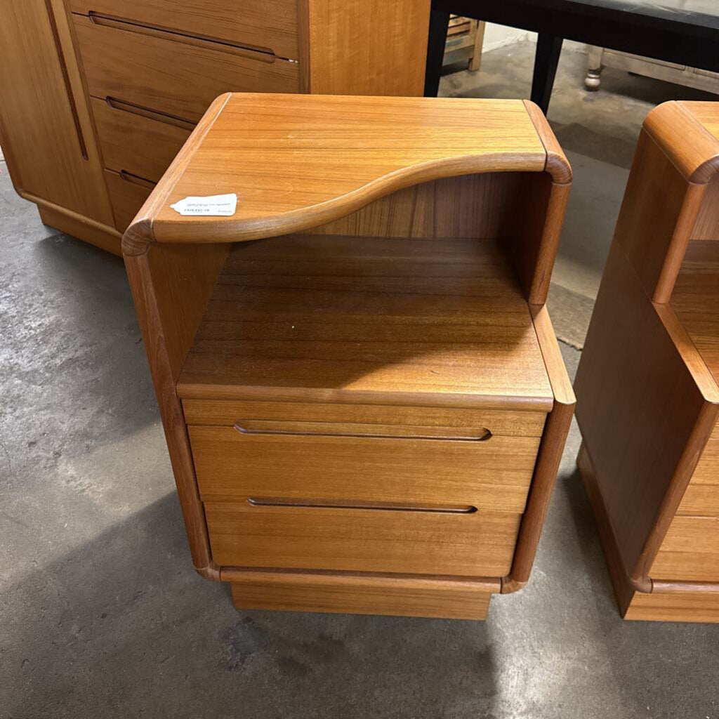 Wooden nightstand with two drawers on a concrete floor