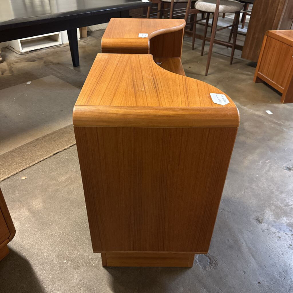 Wooden furniture piece on a concrete floor with other furniture in the background