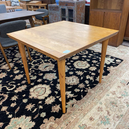 Wooden table on a patterned rug in an indoor setting