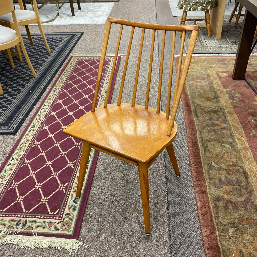 Wooden chair on a patterned rug with other chairs in the background