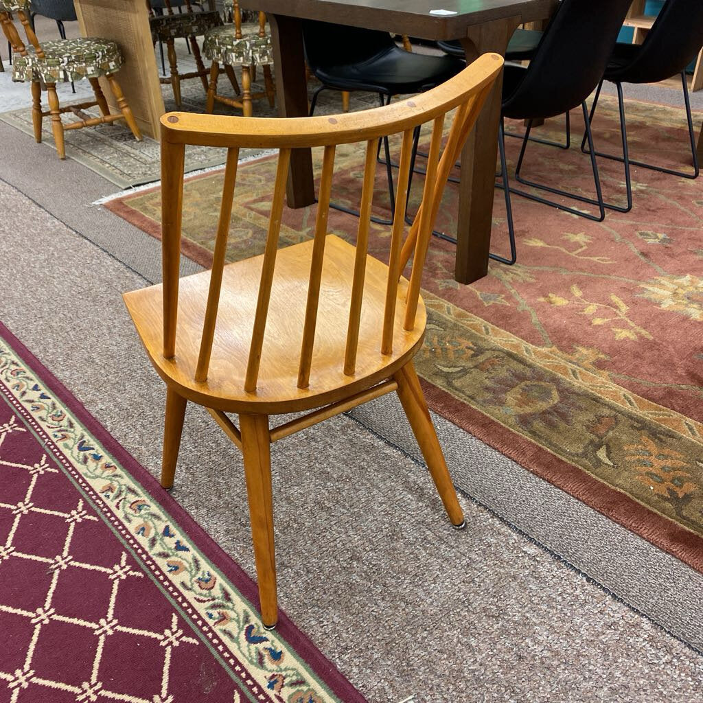Wooden chair on a patterned carpet with tables and chairs in the background