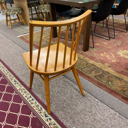 Wooden chair on a patterned carpet with tables and chairs in the background