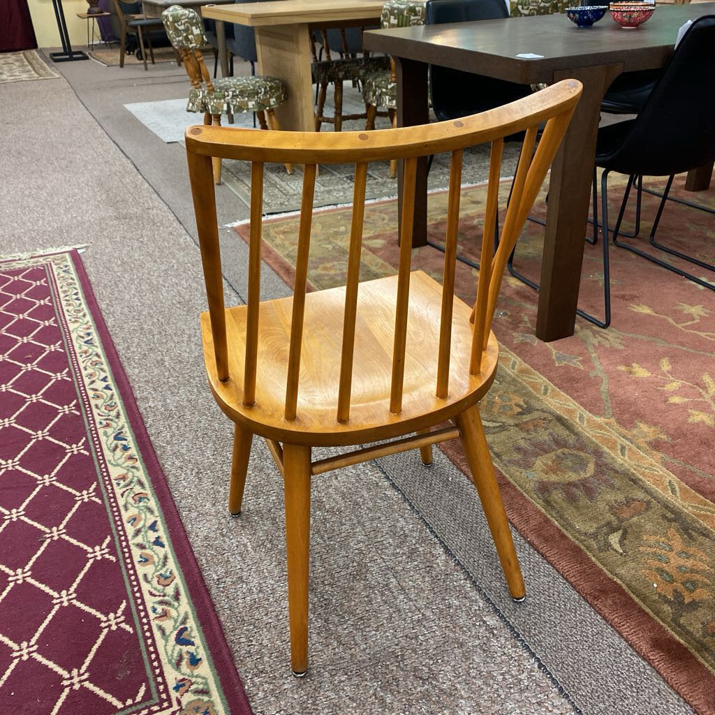 Wooden chair on a patterned carpet with tables and chairs in the background