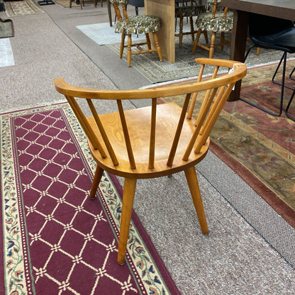 Wooden chair on a patterned rug with a blurred background