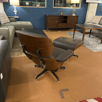 Modern lounge chair in a living room setting with gray sofa and wooden furniture.