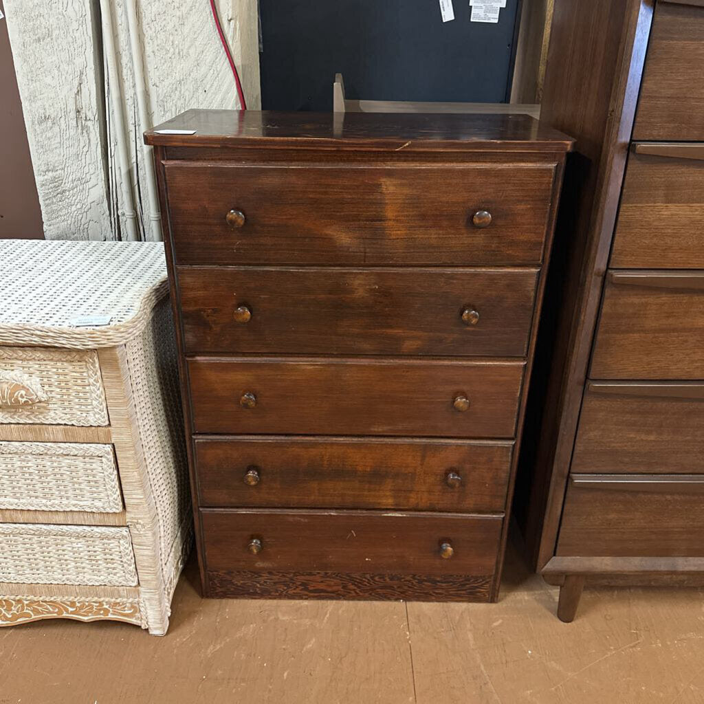 Wooden dresser with four drawers in a storage or warehouse setting