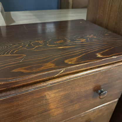 Close-up of a wooden dresser with a visible grain pattern.